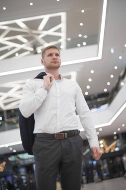 adam omzunun binanın içinde bir ceket ile