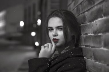 Kızla gece şehirde. Siyah beyaz fotoğraf.