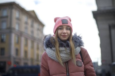 Pembe bir ceket bir kız kış aylarında şehirde yürür.