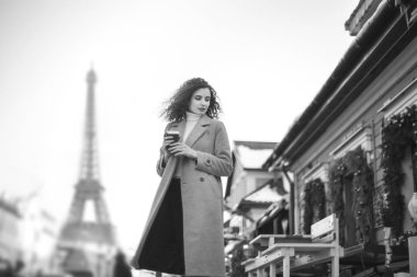 Kahve Eyfel Kulesi arka planı paltoyla kız. siyah beyaz fotoğraf