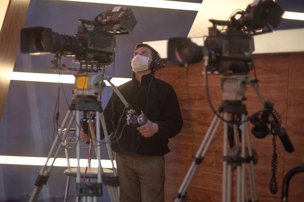 masked cameraman is filming a television show in the studio. TV