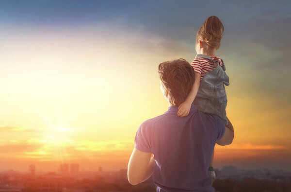 Happy loving family. Father and his daughter child playing and hugging outdoors. Cute little girl and daddy. 
