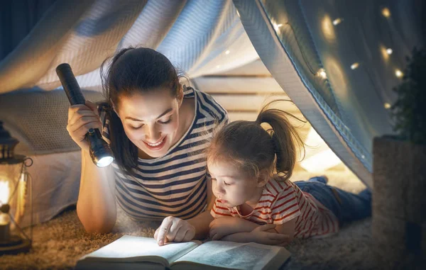 家族の就寝 ママと子の娘は テントの中で本を読んでいます かなり若い母親と子供部屋で楽しく素敵な女の子 — ストック写真