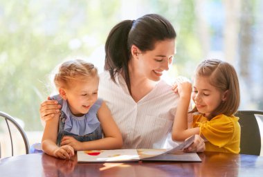 mutlu sevgi dolu aile. oldukça genç anne kızları için bir kitap okuma