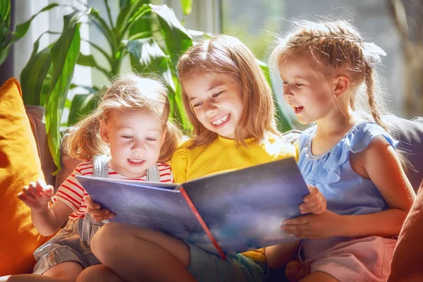 Cute Children Girls Reading Book Sitting Sofa Room Home — Stock Photo, Image