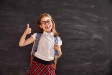 Okula dönüş! Mutlu sevimli çalışkan çocuk kapalı. Çocuk sınıf içinde yazı tahtası üzerinde arka plan öğrenme. 