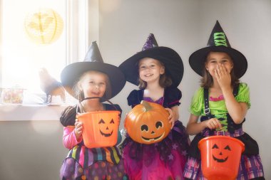 Cadılar Bayramınız Kutlu Olsun! Üç sevimli küçük gülen kız cadı kostümleri.