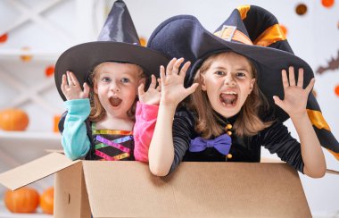 Cadılar Bayramınız Kutlu Olsun! İki sevimli küçük gülen kız cadı kostümleri.