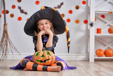 Cadılar Bayramınız Kutlu Olsun! Sevimli küçük gülen kız cadı kostüm balkabağı ile.