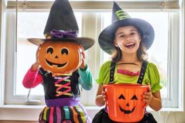 Cadılar Bayramınız Kutlu Olsun! İki sevimli küçük gülen kız cadı kostümleri.