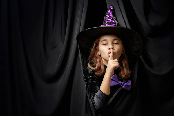 楽しいハロウィンをお過ごし下さい 黒い壁の背景に魔女の衣装でかわいい笑う女の子 — ストック写真