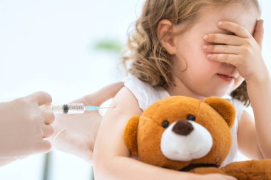 A doctor making a vaccination to a child clipart