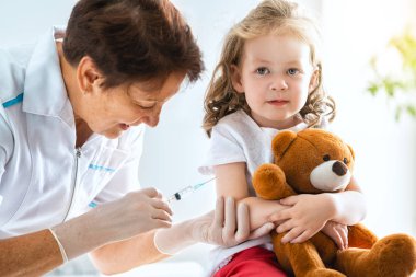 A doctor making a vaccination to a child clipart