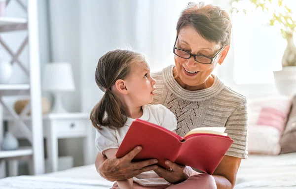 祖母は孫娘に本を読んでいた 家族の休日と友情 — ストック写真