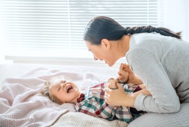 Güzel bir kız bebek ve annesi güneşli bir sabahın tadını çıkarıyorlar. Evde iyi vakit geçir.. 
