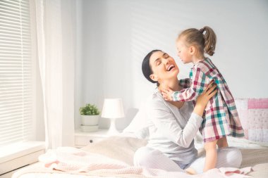 Güzel bir kız bebek ve annesi güneşli bir sabahın tadını çıkarıyorlar. Evde iyi vakit geçir.. 