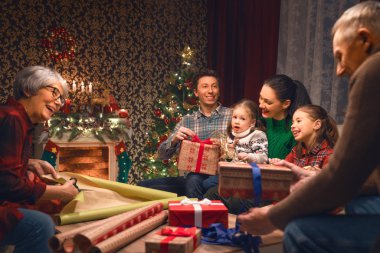 Mutlu Noeller ve mutlu yeni yıl! Büyükanne, Büyükbaba, Anne, baba ve kızı yakınındaki ağaç evde. Aile Tatil Hazırlanma.