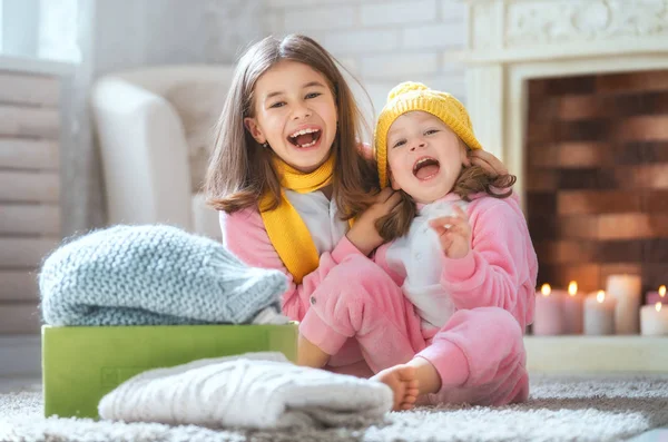 Meninas Bonitos Sentados Chão Segurando Roupas Quentes Malha Crianças Desfrutando — Fotografia de Stock