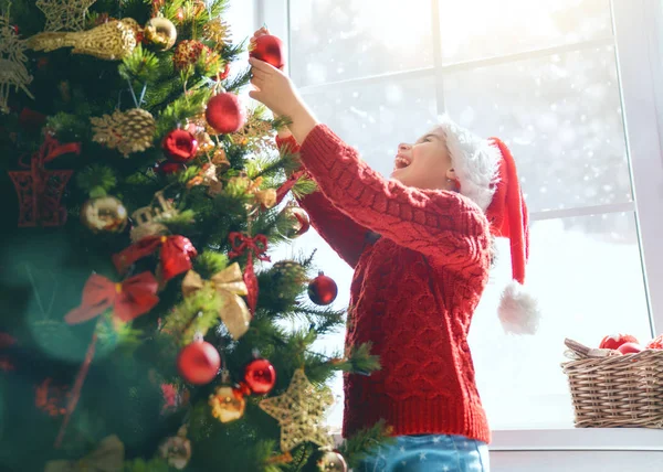 メリー クリスマスとハッピー ホリデー かわいい子女の子は 屋内でのツリーを飾っています クリスマス前に朝 肖像画子供をクローズ アップ — ストック写真
