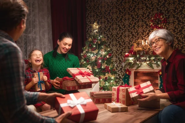 圣诞快乐 节日快乐 爸爸和孩子交换礼物 父母和女儿在室内的树附近玩得很开心 爱的家庭与礼物在房间里 — 图库照片