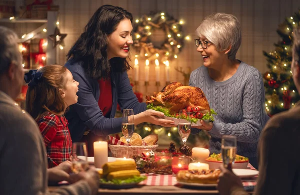 メリークリスマス 幸せな家族は家で夕食を食べている ツリーの近くでお祝いの休日と団結 — ストック写真