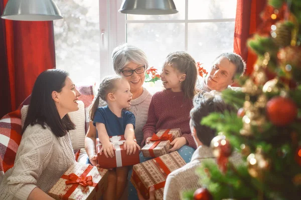 メリー クリスマスとハッピー ホリデー おばあちゃん おじいちゃん お母さん お父さんと子供のプレゼント交換します 両親と屋内で木の近く楽しんで娘 部屋で愛する家族を提示します — ストック写真