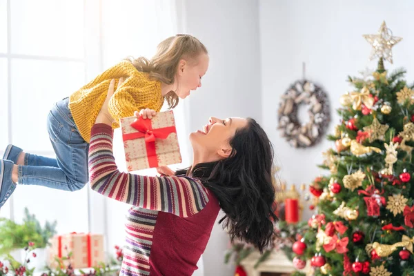 圣诞快乐 节日快乐 快乐的妈妈和她可爱的女儿交换礼物 父母和小孩在树旁玩得开心 有礼物在房间里的爱的家庭 — 图库照片