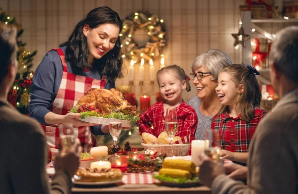 メリークリスマス 幸せな家族は家で夕食を食べている ツリーの近くでお祝いの休日と団結 — ストック写真