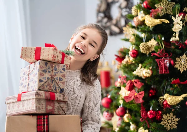 メリー クリスマスとハッピー ホリデー 自宅の木の近くの現在のギフト箱とかわいい子女の子 — ストック写真