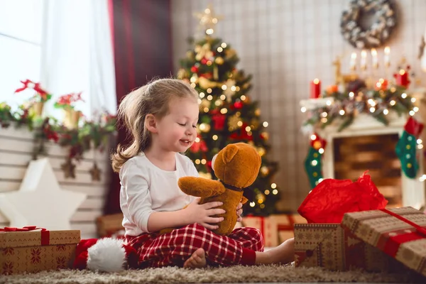 节日快乐 可爱的小孩子在圣诞树附近打开礼物 女孩笑着享受着礼物 — 图库照片