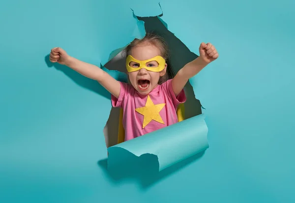 Ett Litet Barn Leker Superhjälte Grabben Bakgrunden Ljusblå Vägg Flickkraftskoncept — Stockfoto