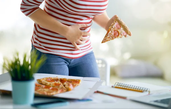 工作时在桌子上吃比萨饼 肚子有问题的女人 — 图库照片