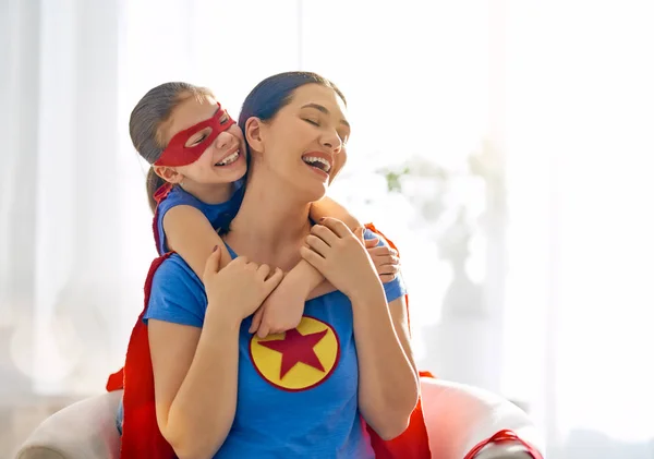 母と彼女の子供は一緒に遊ぶ 女の子とスーパー ヒーローの衣装のお母さん ママし 子供の楽しい ハグします 家族の休日と一体感 — ストック写真