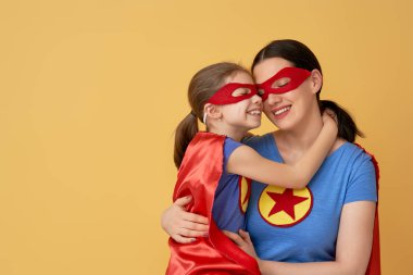 Anne ve çocuğu birlikte oynama. Kız ve anne süper kahraman kostümleri. Annem ve eğleniyor ve gülen çocuk. Aile tatili ve beraberlik.