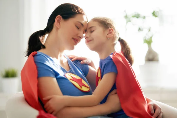 Meisje en moeder in een superheld kostuum — Stockfoto