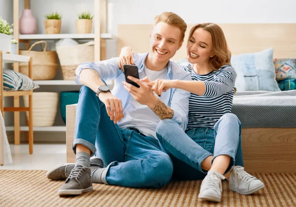 Casal está usando smartphone em casa — Fotografia de Stock