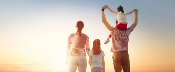 Família feliz ao pôr do sol . — Fotografia de Stock