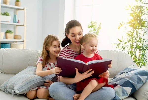 Mãe lendo um livro para filhas — Fotografia de Stock