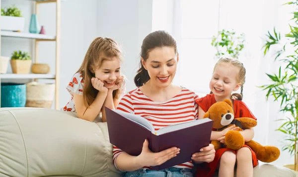 Mãe lendo um livro para filhas — Fotografia de Stock