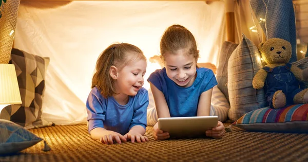 As crianças estão brincando com tablet na tenda — Fotografia de Stock