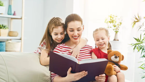 Мать читает книгу своим дочерям — стоковое фото
