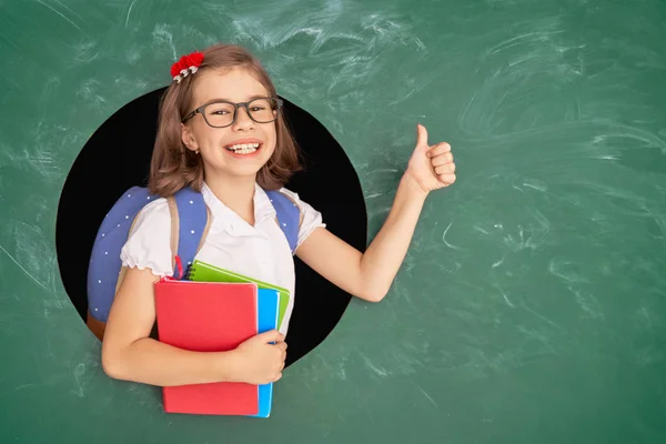 Niño en clase sobre fondo de pizarra . —  Fotos de Stock