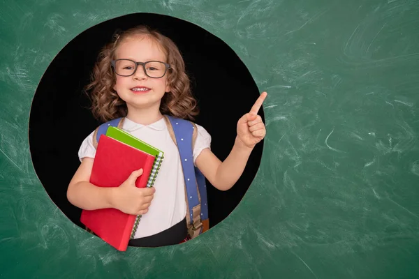 Kind in de klas op achtergrond van schoolbord. — Stockfoto