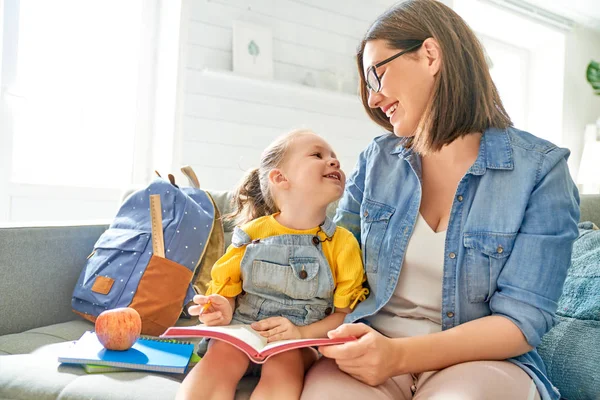 Moeder en haar dochter zijn schrijven in notebook. — Stockfoto