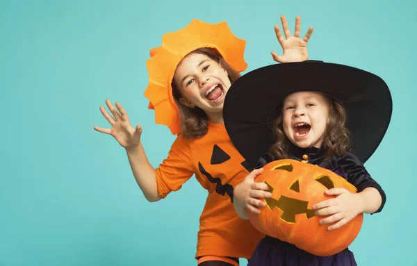 Pequeña bruja y calabaza sobre fondo turquesa — Foto de Stock