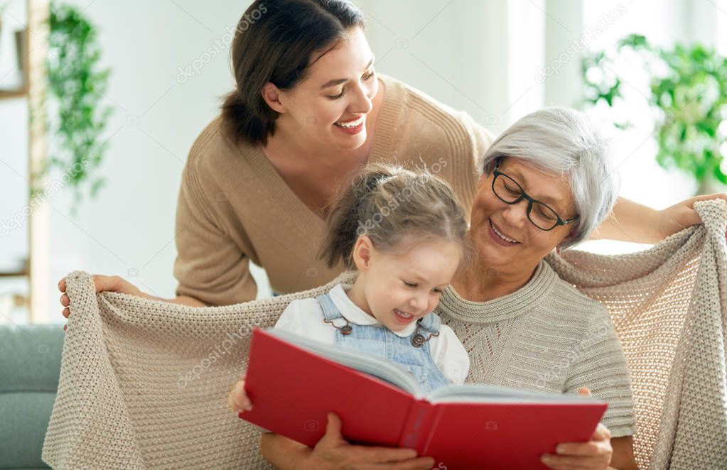 Grandmother reading a book to her granddaughter.