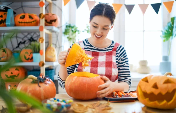 Woman is carving pumpkin — Stock Photo, Image