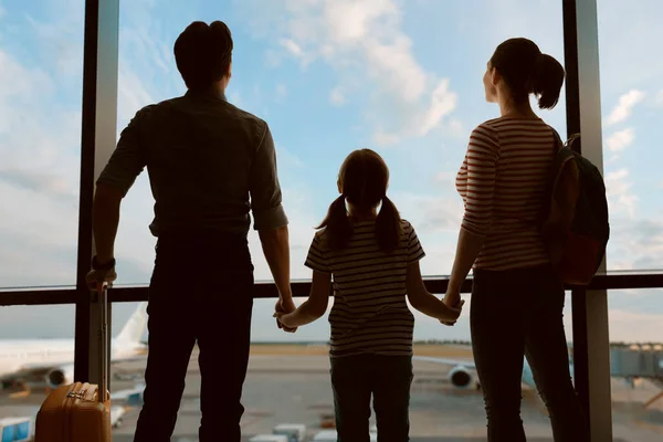 공항에 아이가 부모들 자녀들은 창밖으로 비행기를 바라본다 — 스톡 사진