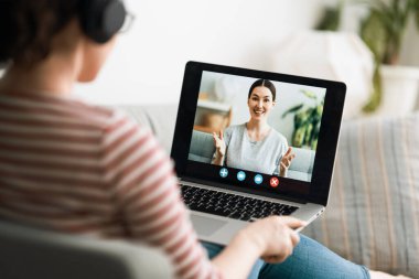 Genç kadın bilgisayarını uzaktan konuşma ve görüntülü konuşma için kullanıyor.. 