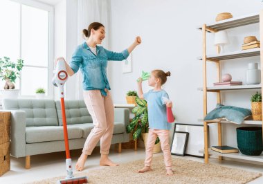 Mutlu aile odayı süpürüyor. Anne ve kızı evde temizlik yapıyor..
